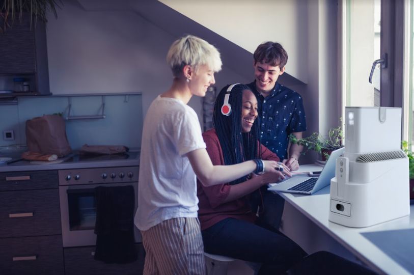 Young Adults In Kitchen With Purified Air Device